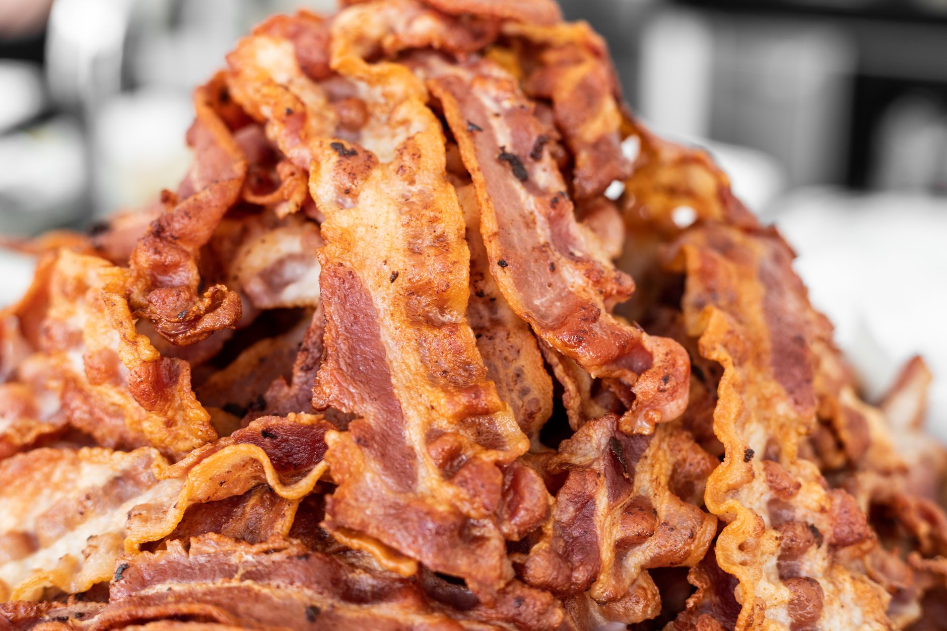 BACON — a strip of cured meat